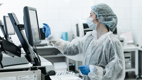 Doctor working on a sensitive equipment in a cleanroom