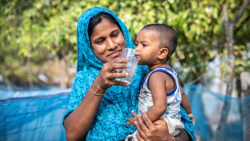 Woman and child drinking glass of water