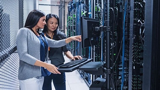 Two engineers standing in front of Data Center talking.