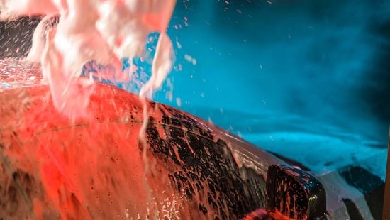 Close up of foam on a car being washed in car wash.
