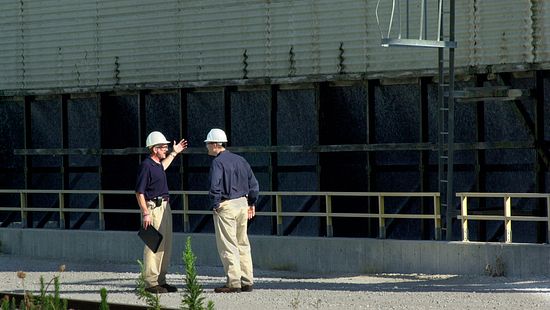 Two men in hard hats talking outside data center cooling tower